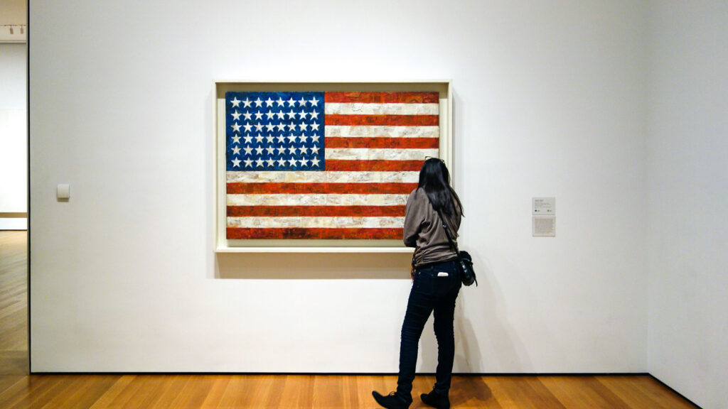 Designer Jasper John's American flag viewed by a museum patron. 